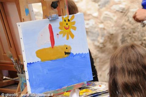 Child's painting of a sailboat on an easel outdoors
