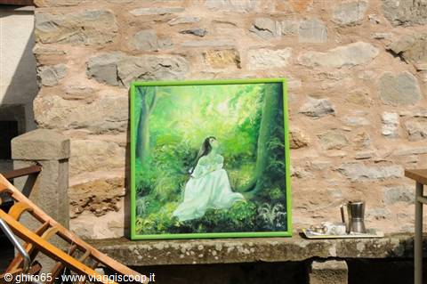 Painting of woman in white in a forest leaning on stone wall, sunlight
