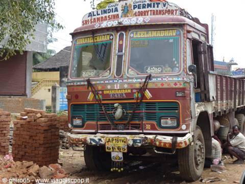 Decorated Tata truck in India, parked beside stacks of bricks