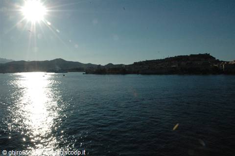 High sun glitters on the sea before the hilltop fortified town
