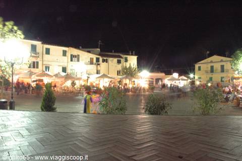Night market square with lit umbrellas and colorful houses