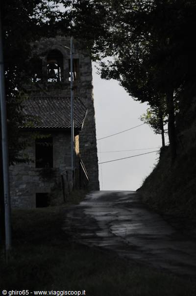 Stone bell tower among trees along a country road