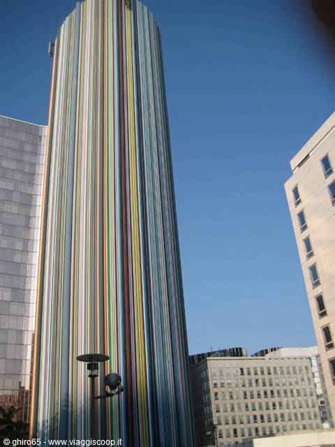 Skyscraper wrapped in multicolored vertical stripes among modern buildings