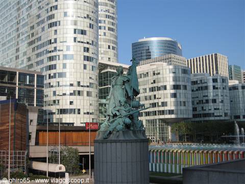 Bronze statue before the curved glass towers of La Défense, Paris