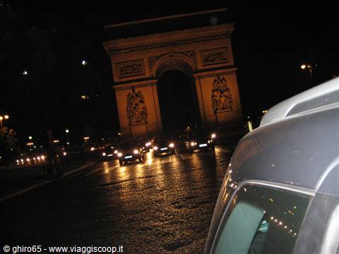 Illuminated Arc de Triomphe at night, headlights of traffic on Champs-Élysées