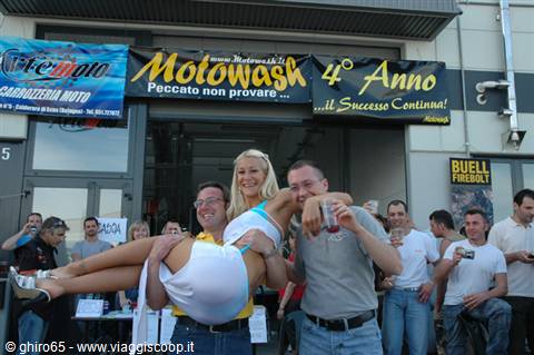 Two men lifting a blonde woman outside the Motowash dealership