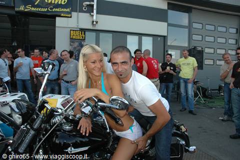 couple posing on a black motorcycle at a Buell rally before a crowd