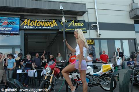 Blonde girl in white top at Motowash anniversary, motorcycles and crowd around