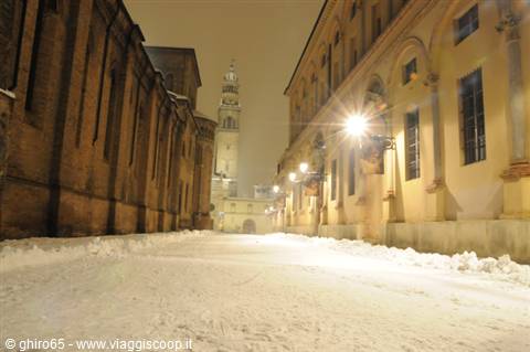 Snow-covered Piazza Duomo in Parma at night, Romanesque bell tower glowing