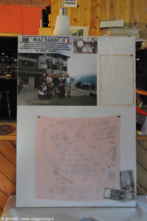 Mai Tardi hut memory: group photo, drawings and banknotes pinned on wood