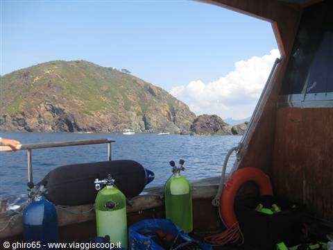 Colorful diving tanks on a boat deck facing Elba island