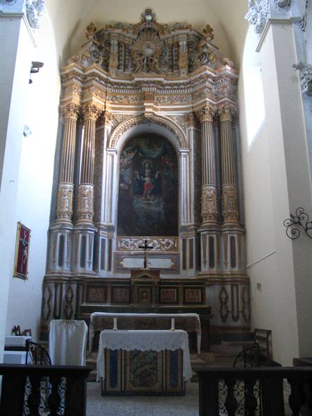 Baroque polychrome marble high altar with painted altarpiece, soft side daylight