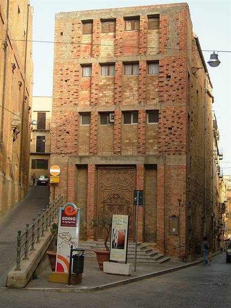 Brick building with large carved portal at a sloping street corner