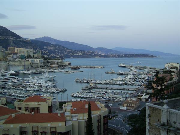 Port Hercules in Monte Carlo, yachts moored among rooftops and mountains at dusk