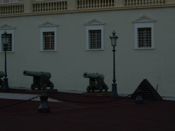 Old bronze cannons lined up in front of the palace facade