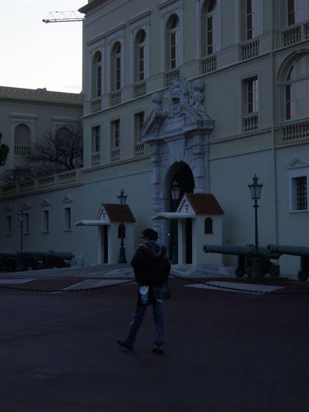Tourist walks in front of the Prince's Palace of Monaco entrance near old cannons