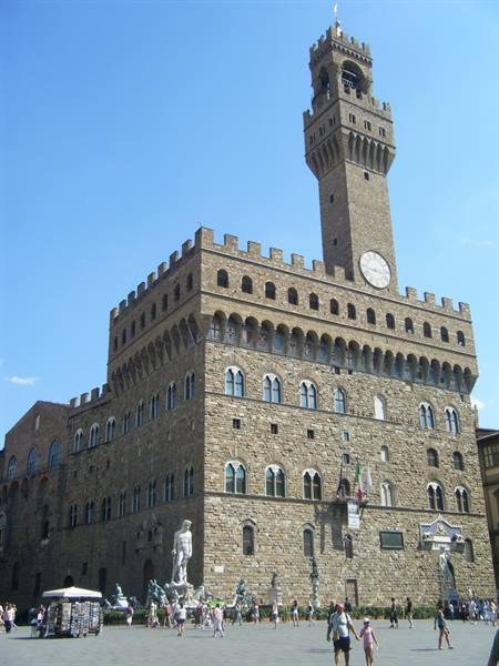 Palazzo Vecchio with Arnolfo tower, tourists in Piazza della Signoria, Florence