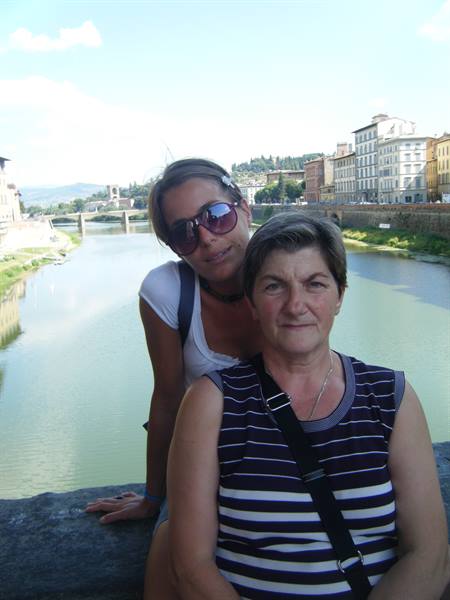 Two smiling women on a stone bridge over the Arno, Florence