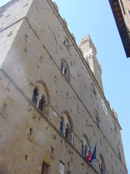 Palazzo Vecchio in Florence, stone facade with crenellated tower and flags