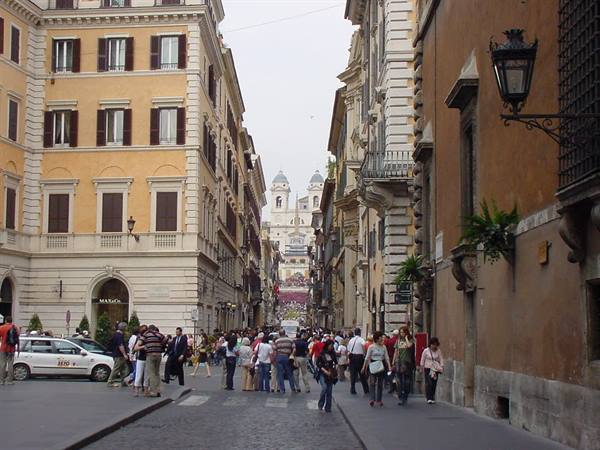 Tourists walk along Via dei Condotti toward Trinità dei Monti, Rome