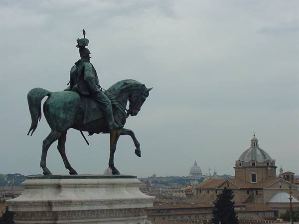Bronze equestrian statue at the Vittoriano, Roman domes under a grey sky