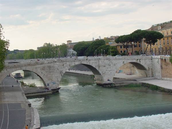 Stone Ponte Cestio arches over the Tiber in Rome, soft daylight on embankments