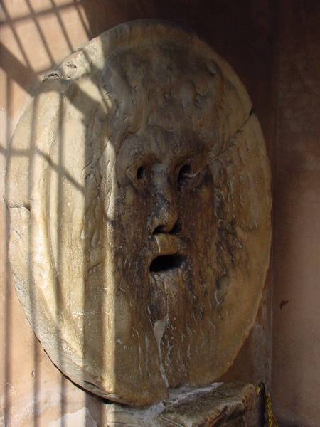 The Bocca della Verità marble mask, sunlight striped through the grate