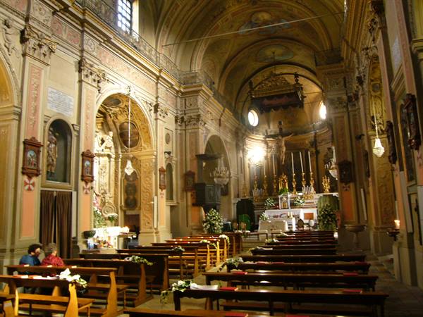 Baroque church nave with altar decorated for a wedding, wooden pews and natural light