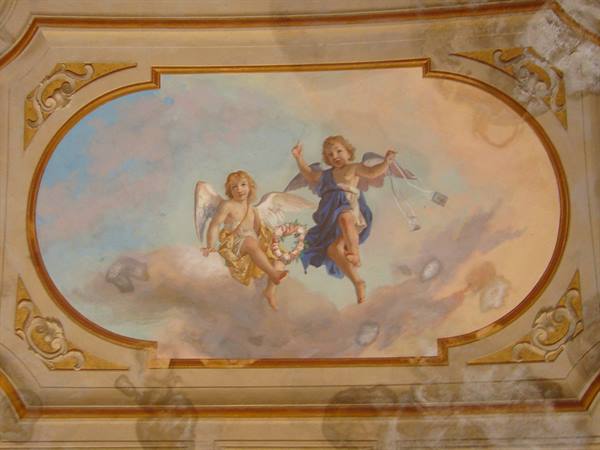 Fresco with two cherubs on clouds inside a golden oval frame