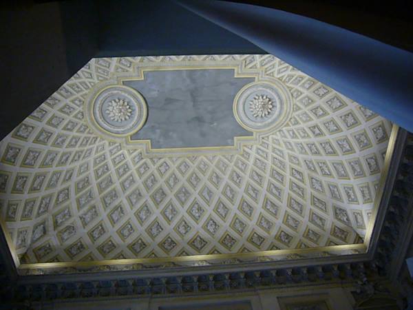 White and gold coffered ceiling with stucco rosettes seen from below
