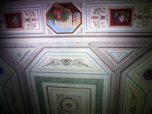 Frescoed ceiling with green geometric stuccoes, floral panels and painted landscape