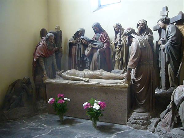 Wooden sculptural group of the Lamentation around Christ's body, flowers below