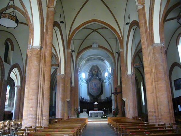 Church interior with brick columns, central nave and wooden pews