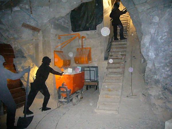 Mannequin miners with orange cart inside mine tunnel with stairs