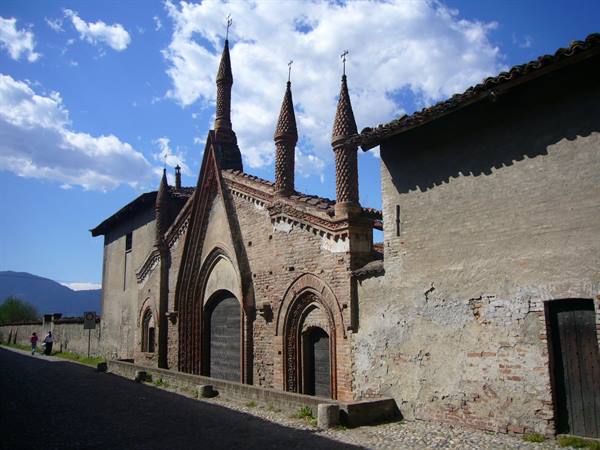 Brick facade with gothic spires, blue sky with clouds