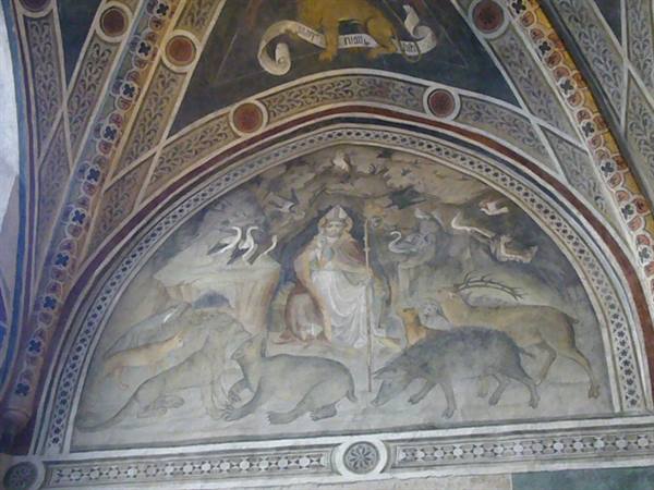 Fresco of a saint enthroned surrounded by animals inside a painted arch