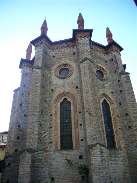 Gothic brick church with pinnacles and tall arched windows under daylight