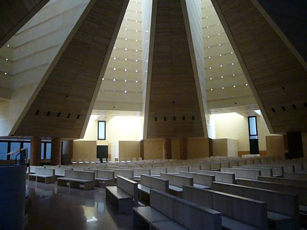 Inside Jubilee Church in Rome, white concrete sails above wooden pews
