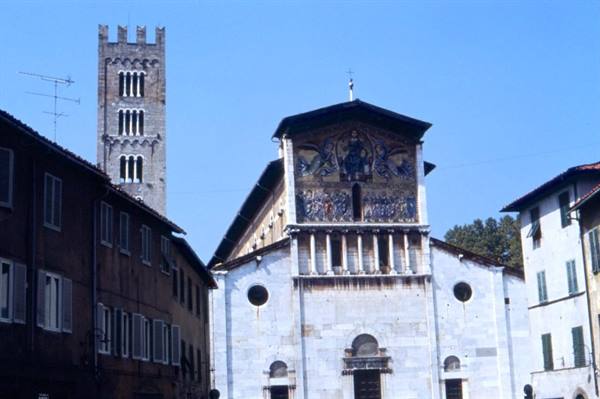 Marble facade of San Frediano basilica in Lucca with mosaic and bell tower