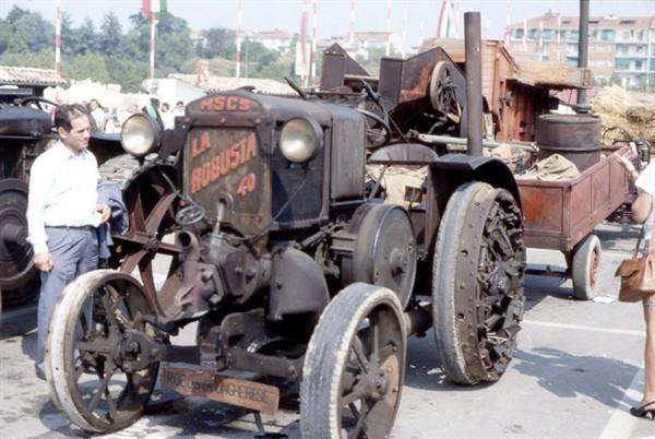 Old steel tractor "La Robusta 40" at a fair, man in white shirt beside