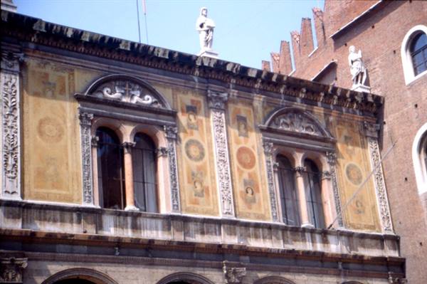 Frescoed facade of the Loggia del Consiglio in Verona with mullioned windows and marble statues