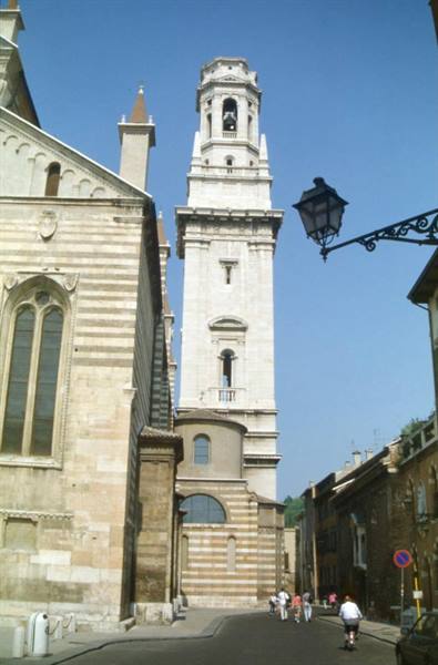 The marble bell tower of Verona Cathedral above the street with pedestrians