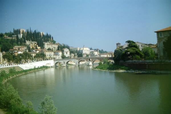 Ponte Pietra over the Adige in Verona, houses and cypresses on the hill