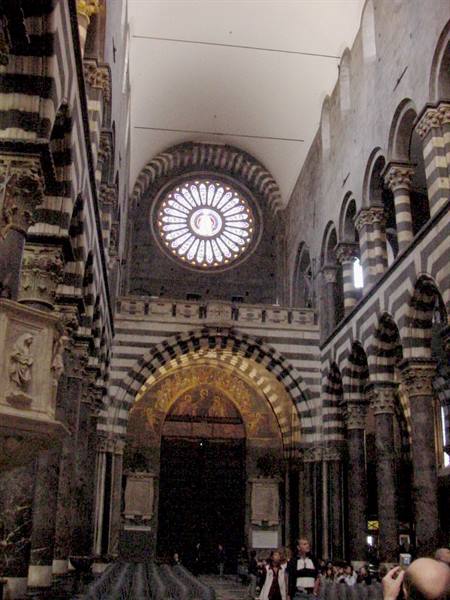 Inside Genoa Cathedral, rose window and golden mosaic above the portal