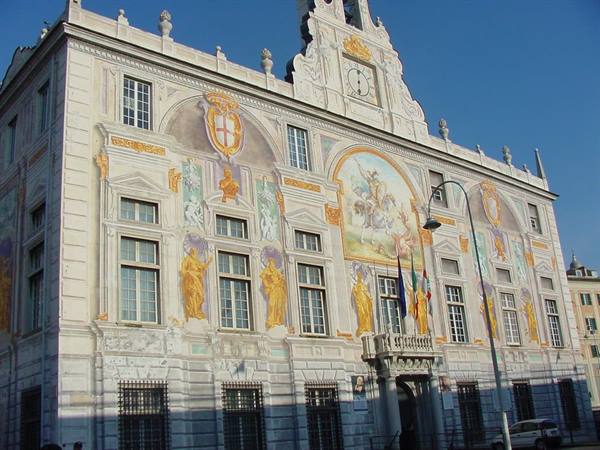 Palazzo San Giorgio in Genoa, frescoed facade with gilded statues in sunlight