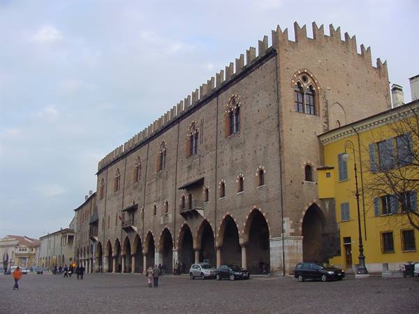 Palazzo Ducale in Mantua, brick facade with arches, people and cars in the square