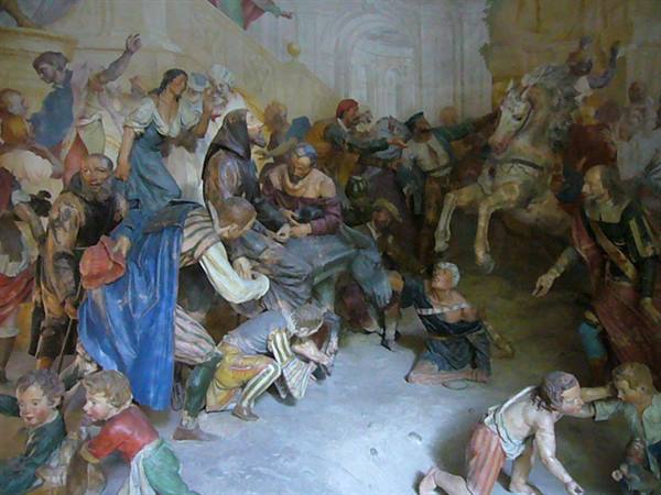Painted terracotta statue group: peasant crowd and rearing horse, soft light