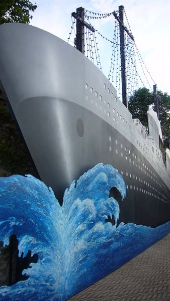 Mural of a gray ship bow over a painted blue wave
