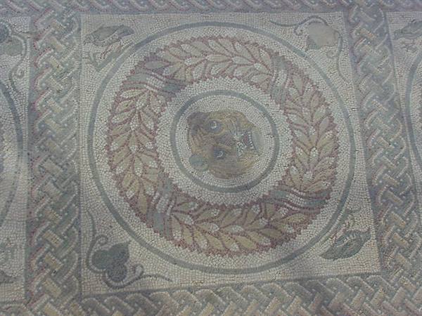 Roman mosaic with a feline head inside a wreath of leaves