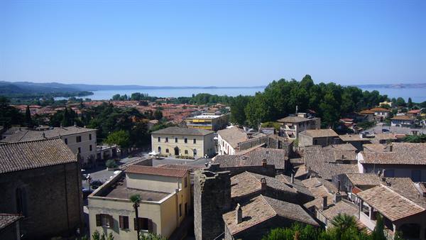 Stone roofs of the old town with the blue lake in the background, midday